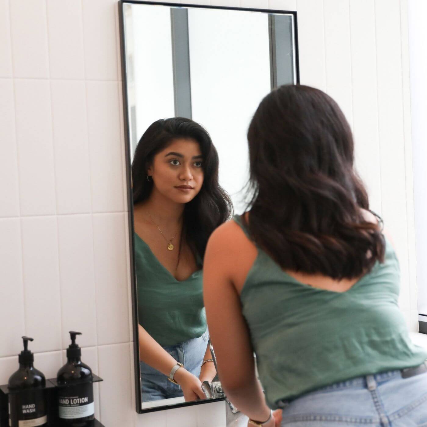 Young woman looking at herself in mirror