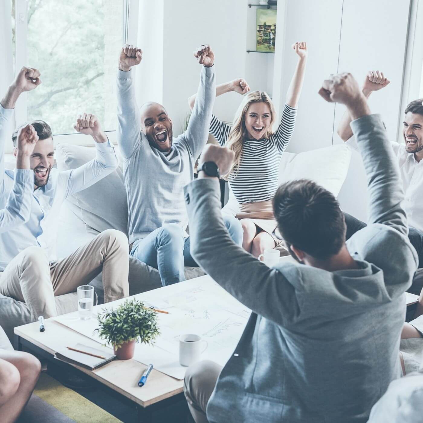 Group of people celebrating with their hands in the air